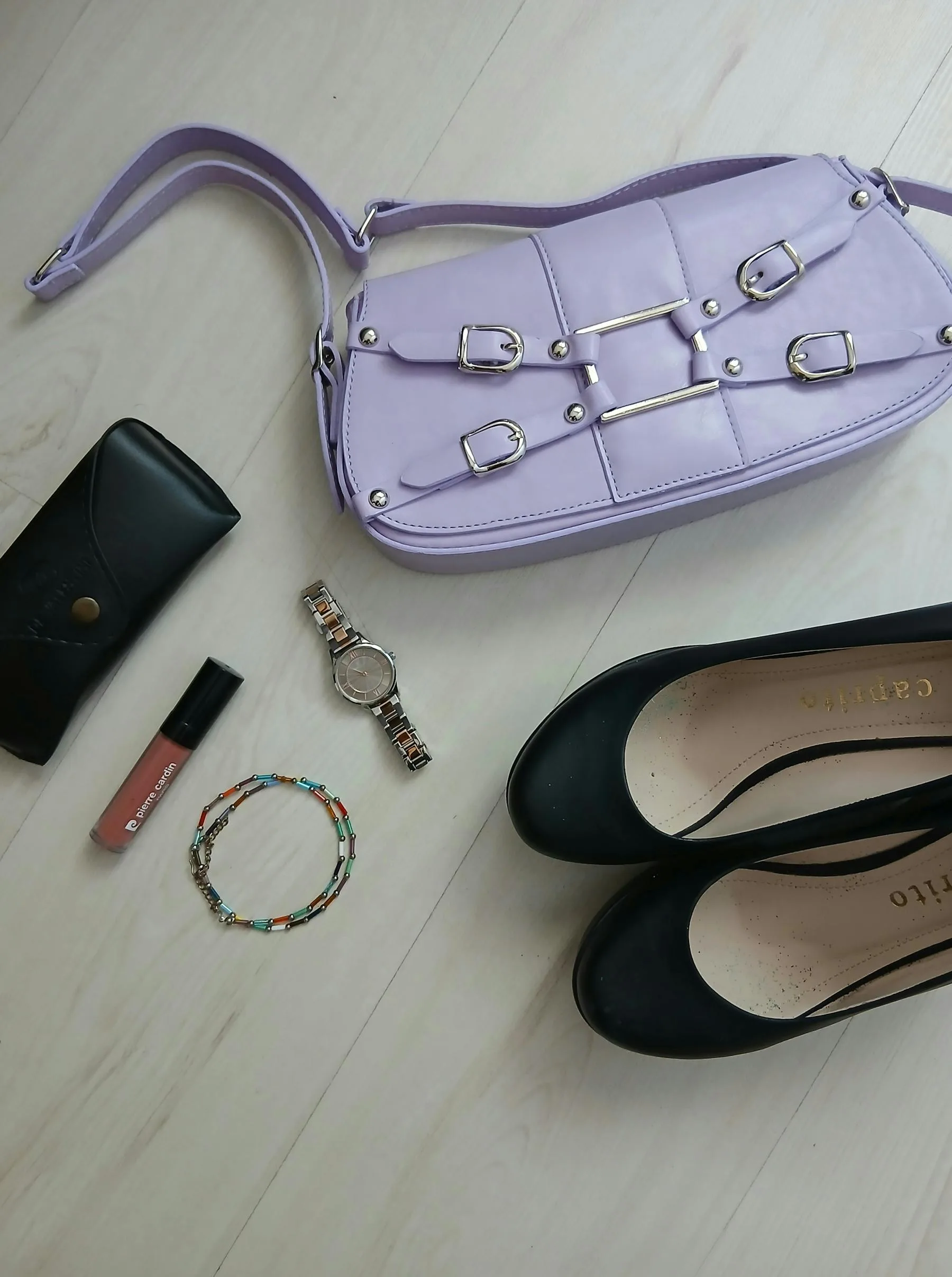Shoes, bag, jewelry, and fashion items arranged for a styled outfit